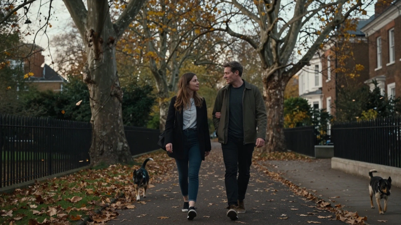Two people walking peacefully along a tree-lined path in Hampstead Heath during autumn.