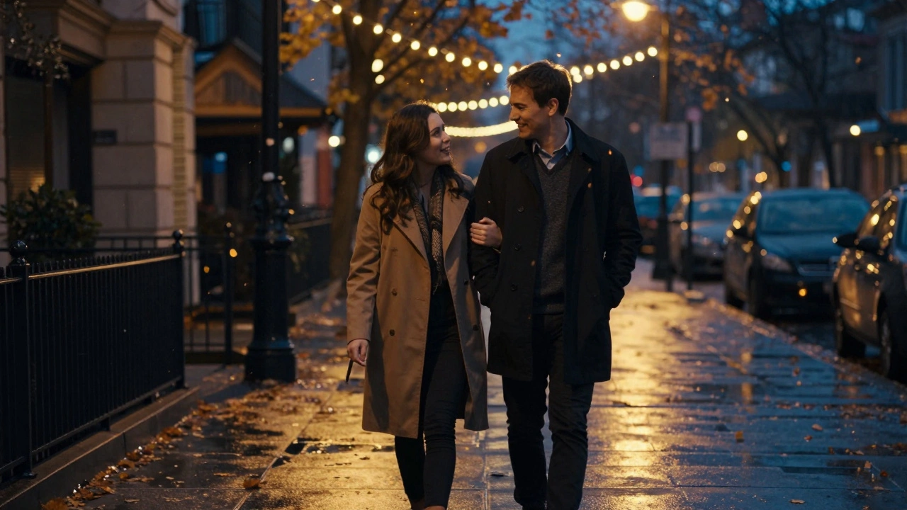 A man and woman walking arm in arm along a city sidewalk at dusk, laughing in quiet companionship.